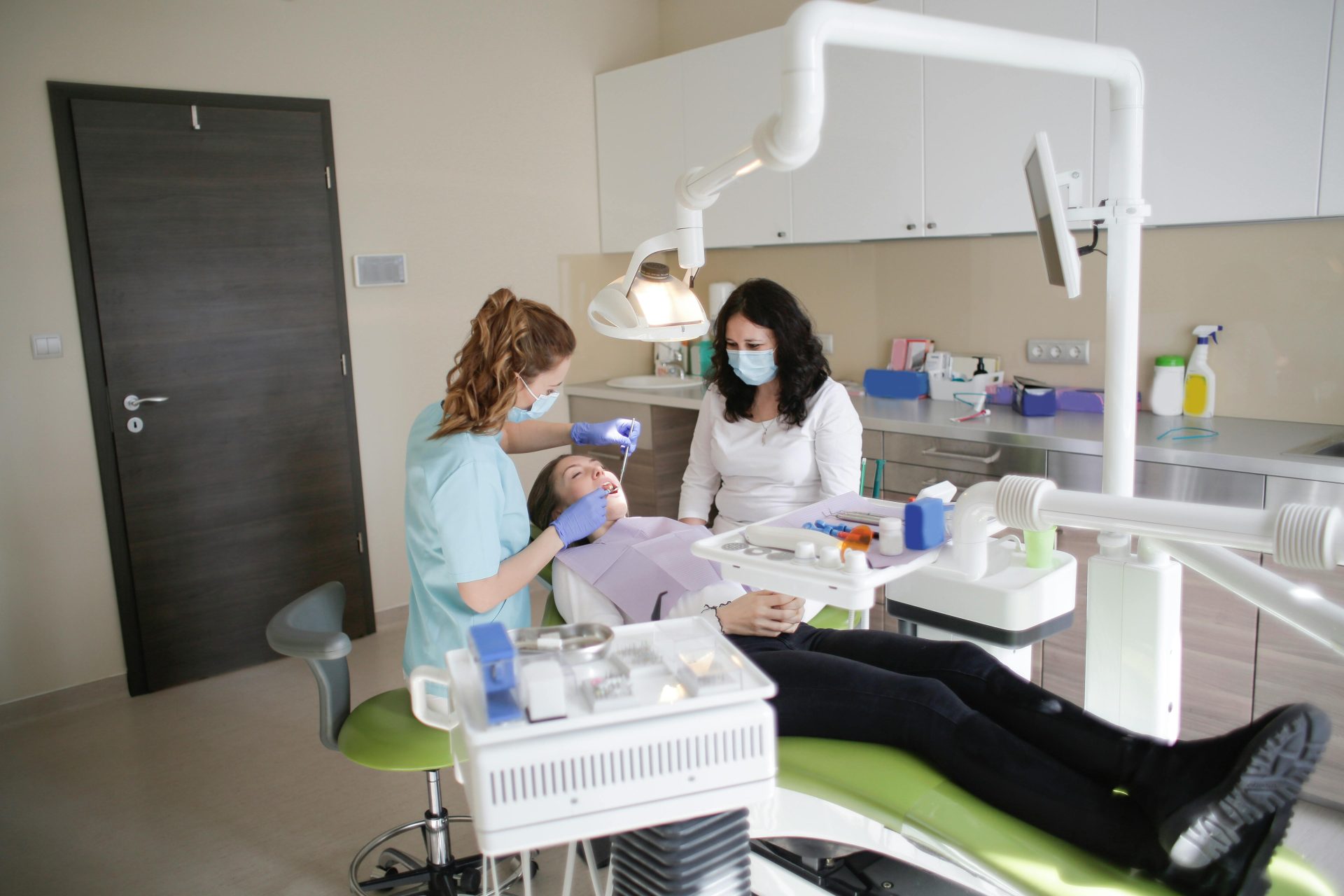 Female dentist performs treatment on a patient in a modern dental clinic.